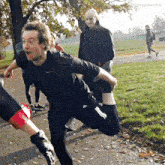 a man in a black nike shirt stretches his leg