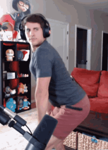 a man wearing headphones is squatting in front of a microphone