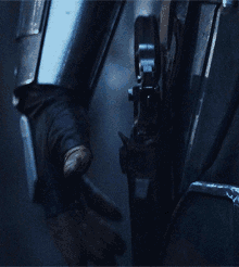 a close up of a person holding a gun in a dark room