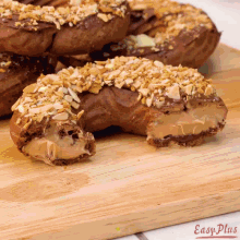 a donut with a bite taken out of it is on a wooden cutting board with easy plus written on it