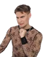 a man wearing a sheer shirt and a chain around his neck is making a funny face