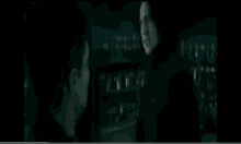 a man and a woman are talking in a dark room