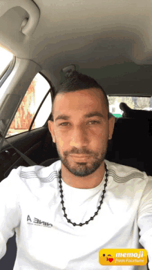 a man with a beard wearing a white shirt that says a3mn