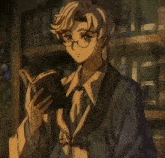 a man with glasses is reading a book in front of bookshelves