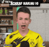 a young man wearing a yellow bvb jersey