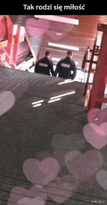 two police officers standing on a set of stairs with the words tak rodzi się miłosc on the bottom