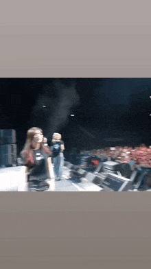 a blurry picture of a woman on a stage in front of a crowd