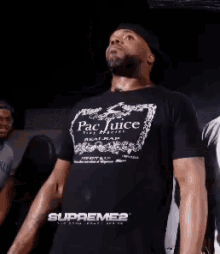 a man wearing a pac juice t-shirt is dancing