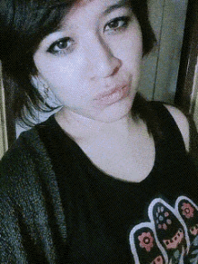 a close up of a woman 's face wearing a black shirt with flowers on it