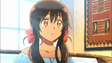 a girl with a red bow in her hair is sitting on a bed