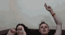 a man and woman with their arms in the air