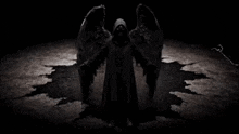 a grim reaper with his arms outstretched stands in the dark