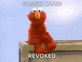 elmo from sesame street is sitting on the edge of a building and says gamer card revoked .