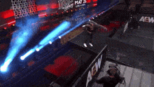 a wrestler in a ring with a aew sign in the background