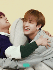 two young men are hugging each other and one of them is smiling .