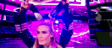 a woman is standing on a stage with a purple background holding a trophy .