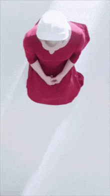 a woman in a red dress is kneeling down