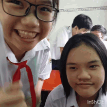 a girl wearing glasses and a red tie smiles for a picture