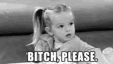 a little girl is sitting at a table with the words `` bitch please '' written on it .