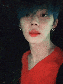 a close up of a person 's face with blue hair and red lips .