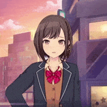 a girl in a school uniform with a red bow tie stands in front of a building