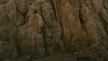 a robot is flying through the air near a rocky cliff