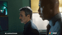 two men are standing next to each other with a nbc logo on the bottom right
