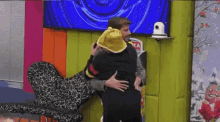 a man wearing a yellow hat is being hugged by another man