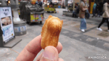 a person is holding a peanut in their hand with the words made in animotica behind them