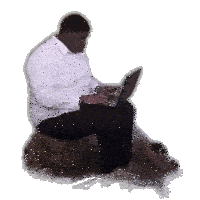 a man in a white shirt is sitting on a rock using a laptop computer .