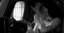 a man and a woman are kissing in a car .