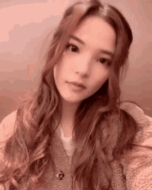 a woman with long hair is taking a selfie with her phone