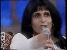 a woman is holding a microphone in front of her mouth .