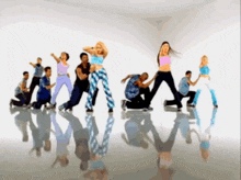 a group of people are dancing in a room with their reflections on the floor