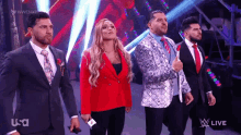 a group of people in suits and ties are standing on a stage in front of a screen that says usa live .