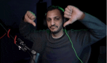 a man wearing headphones giving a thumbs down