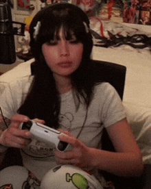 a woman wearing headphones is playing a video game with a controller