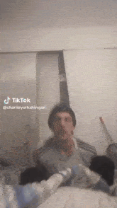 a tiktok video of a man laying on a bed with the name charlie yorkshirepal
