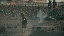 a person playing a guitar with the letter e on the back of their shirt