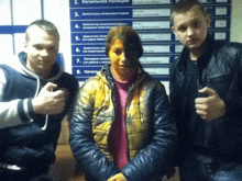 two men and a woman are posing for a picture in front of a sign that says " начальник полиции " on it