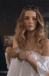 a woman wearing a white off the shoulder top and a headband