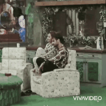 a man and woman are sitting on chairs in a living room .