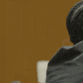 a man in a suit and tie is hugging a woman with braids .