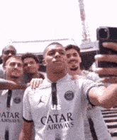 a group of men are taking a selfie and one of them is wearing a shirt that says ' us ' on it