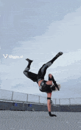a person is doing a handstand in front of a sign that says ' viggle.ai ' on it