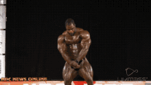a man flexes his muscles in front of a banner that says rdc news online