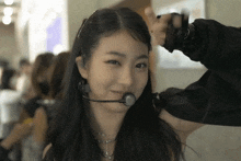 a girl with a microphone in her mouth smiles at the camera