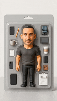 a figurine of a man is surrounded by various objects including a coffee cup and a pen