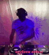 a man wearing headphones and a blue shirt is playing a dj set