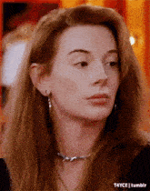 a close up of a woman 's face wearing earrings and a necklace .